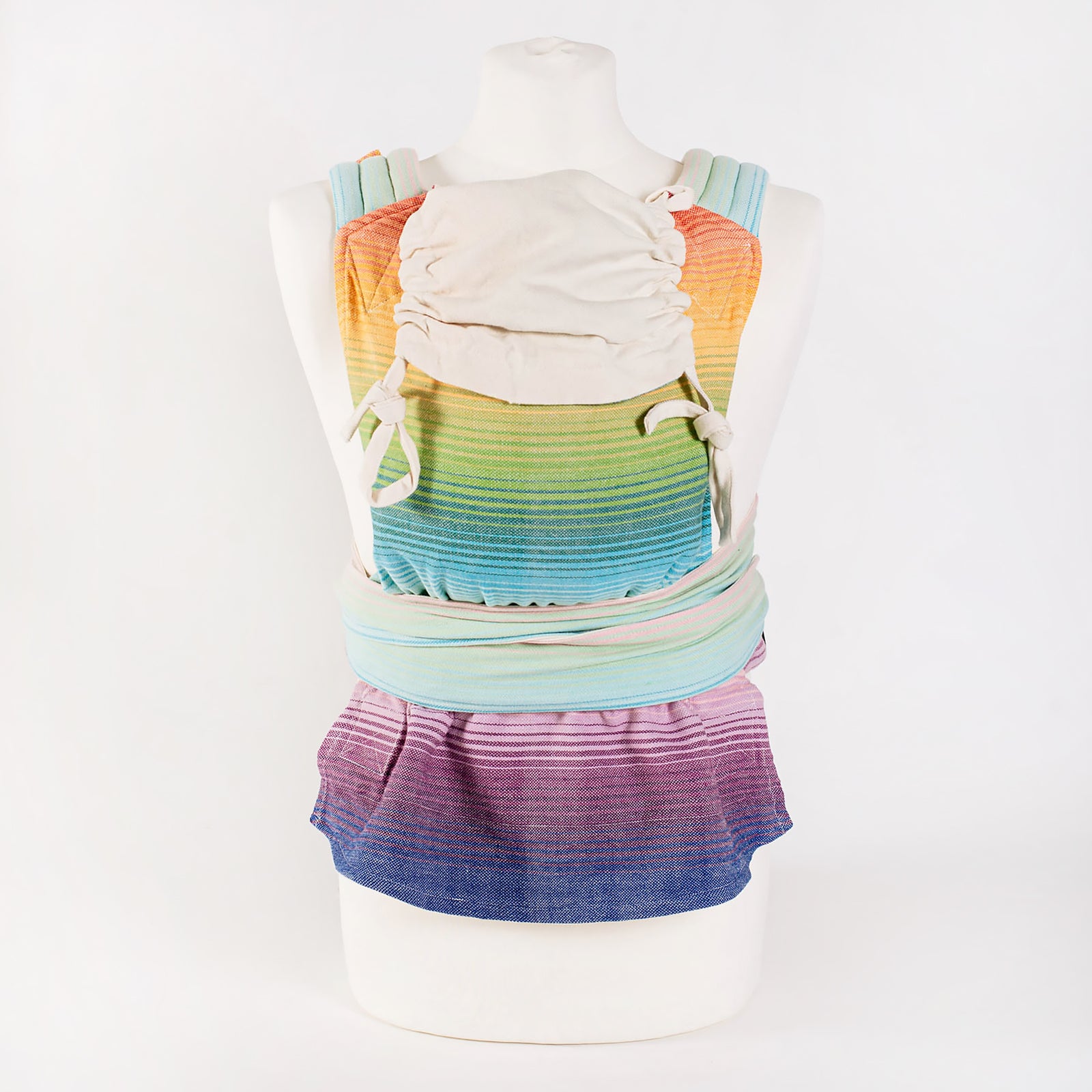 Mutter küsst süßes Baby auf den Kopf in Babytrage Mysol Rainbow Dreamer. 